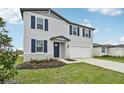 Two-story house with gray siding, navy blue shutters, and a white garage door at 161 Lazy Shore Dr, Nokomis, FL 34275