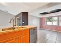Kitchen with double sink, dishwasher, and wood cabinets at 2443 Waterfall Dr, Spring Hill, FL 34608