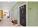 Condo hallway with light walls, tiled floor, and a black door to unit 1205 at 1810 E Palm Ave # 1205, Tampa, FL 33605