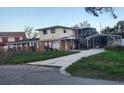 Two-story house with carport and overgrown lawn at 1015 Linden Rd, Venice, FL 34293