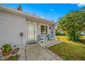 Inviting Florida home with grey exterior, small front porch, and nicely landscaped lawn at 1125 Somerset S Cir, Dunedin, FL 34698