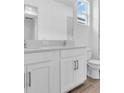 Bright bathroom featuring double vanity sinks, light countertops and modern fixtures at 2515 Wise River Lane, Zephyrhills, FL 33539