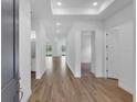 Bright hallway featuring wood flooring, recessed lighting, and neutral walls, creating an inviting entry at 2515 Wise River Lane, Zephyrhills, FL 33539