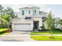 Two-story house with a neutral exterior, attached garage, and landscaping at 2358 Wise River Lane, Zephyrhills, FL 33539