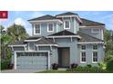 Charming two-story home with gray siding, a dark roof, and an attached garage at 2358 Wise River Lane, Zephyrhills, FL 33539