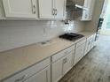 Kitchen featuring white cabinets, quartz countertops, and a tile backsplash at 2358 Wise River Lane, Zephyrhills, FL 33539