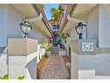 Charming walkway between units with a brick path leading to the front door, and lush plants on either side at 903 Pinellas Bayway S # 302, Tierra Verde, FL 33715