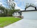 Single-story home with a well-maintained lawn and driveway leading to a spacious two-car garage at 1074 Kacerik St, North Port, FL 34288