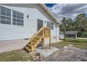 Rear view of the home showcasing stairs and deck at 11335 Pickford St, Spring Hill, FL 34609