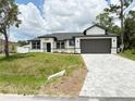 Charming single-story home with a paved driveway and a neatly manicured lawn on a sunny day at 4683 Boston Ter, North Port, FL 34288