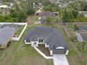 Aerial view of charming new construction featuring a paver driveway and a well manicured lawn at 1081 Mccrory St, North Port, FL 34286