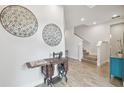 Bright entryway with wood-look floors, antique sewing machine, and staircase at 307 Shore Crab Way, Apollo Beach, FL 33572