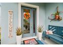 Front entrance with a gray door, welcome sign, and potted plants at 307 Shore Crab Way, Apollo Beach, FL 33572