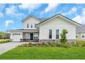 Charming two-story home featuring a two-car garage, stone accents, and well-manicured landscaping at 2626 Wise River Lane, Zephyrhills, FL 33539