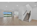 Bright living room featuring tile floors, a staircase and sliding glass doors with scenic views at 2626 Wise River Lane, Zephyrhills, FL 33539