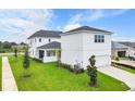 White two-story house with a detached garage and grassy yard at 3611 Lajuana Blvd, Wesley Chapel, FL 33543