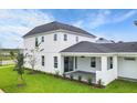 White two-story house with covered patio and landscaped yard at 3611 Lajuana Blvd, Wesley Chapel, FL 33543