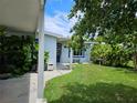 Side view of a light blue house with a covered patio and green lawn at 5400 Circle Dr, Weeki Wachee, FL 34607