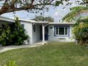 Single-story home with a blue door and a nicely landscaped yard at 5400 Circle Dr, Weeki Wachee, FL 34607