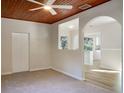 Spacious living room with neutral carpeting and an arched entryway to another room at 10809 N Edison Ave, Tampa, FL 33612