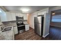 Bright kitchen with white cabinets, stainless steel appliances, and granite countertops at 4901 Aegean Ave, Holiday, FL 34690