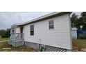 Side view of a single-story home with white siding and a small porch at 3711 Wiggins Leaf St, Tampa, FL 33619