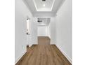 Bright hallway with wood-look floors and access to bathroom at 14038 Cooper Rd, Spring Hill, FL 34609