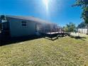 Spacious backyard with a wooden deck and grassy area at 6336 Florida Cir, Apollo Beach, FL 33572