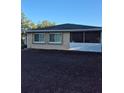 View of home's back exterior featuring screen room, windows, and newly laid dirt at 21300 Washburn Ave, Port Charlotte, FL 33952