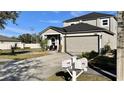 Two-story house with gray siding, a dark roof, and a two-car garage; side yard view at 1057 Brenton Leaf Dr, Ruskin, FL 33570