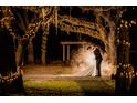 Couple embracing under a canopy of trees with lights at 15625 State Road 62 St, Parrish, FL 34219