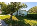 Side view of a light blue house with lush green landscaping at 7839 Primula Ln, New Port Richey, FL 34654