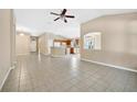 Spacious living room with tile floors and a view into the kitchen at 15838 Cedar Elm Ter, Land O Lakes, FL 34638