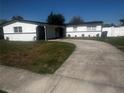 Inviting single-story home with a large concrete driveway and well-kept lawn at 6007 Ambassador Dr, Tampa, FL 33615