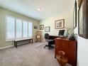 A dedicated office space features a large window, neutral carpet, and comfortable work arrangements at 7729 Rosewood Garden Loop, Tampa, FL 33637