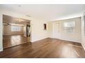 Open living area with wood-look flooring and kitchen view at 5023 Thames Dr, New Port Richey, FL 34652