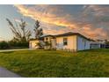 Side view of a single story house with sunset in the background at 10625 Ayear Rd, Port Charlotte, FL 33981