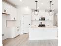 Bright white kitchen featuring an island, stainless steel appliances, and ample storage at 104 Runaway Field Ave, Nokomis, FL 34275