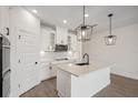 Stylish kitchen boasts white cabinets, quartz countertops, a center island, and stainless steel appliances at 117 Runaway Field Ave, Nokomis, FL 34275
