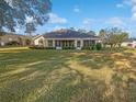 Large backyard with grassy lawn and home with screened porch at 6844 Northlake Dr, Zephyrhills, FL 33542