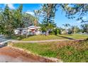 Side view of a house with a red door and green lawn at 2695 S East Ave, Sarasota, FL 34239