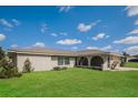 Tan single story house with a large front yard and blue sky at 23104 Newcun Ave, Punta Gorda, FL 33980