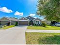 Charming single-story home with a well-maintained lawn and two-car garage at 14308 Edinburgh Moor Dr, Wimauma, FL 33598