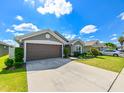 Gray house with brown garage door and landscaping at 14308 Edinburgh Moor Dr, Wimauma, FL 33598