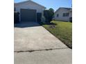 Concrete driveway leading to attached one-car garage at 5770 46Th N Ave, Kenneth City, FL 33709