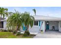 Front exterior view of a single-story home with teal shutters, landscaping, and a carport at 4532 103Rd W St, Bradenton, FL 34210