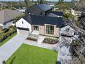 An aerial view showcasing the home's modern design, metal roof, and dual garage setup within a lush, green lawn at 1046 Snell Isle Ne Blvd, St Petersburg, FL 33704