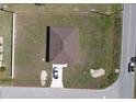 Aerial view of a well-maintained property featuring a grassy lawn and a private driveway with an adjacent street at 1262 Oxsalida St, Port Charlotte, FL 33952
