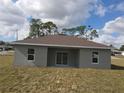 Backyard view of a single-story house with sliding glass doors and windows at 1262 Oxsalida St, Port Charlotte, FL 33952