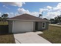 Front exterior of a single-story home with a one-car garage, driveway, and landscaping at 1262 Oxsalida St, Port Charlotte, FL 33952